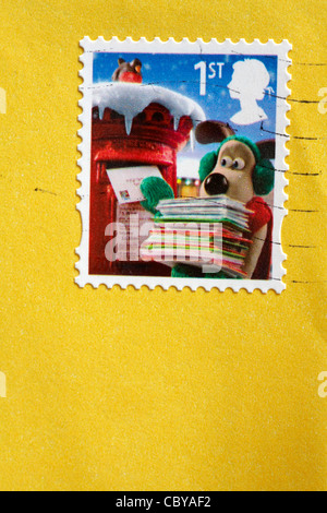 1st class Wallace & Gromit Christmas stamp stuck on yellow envelope Stock Photo