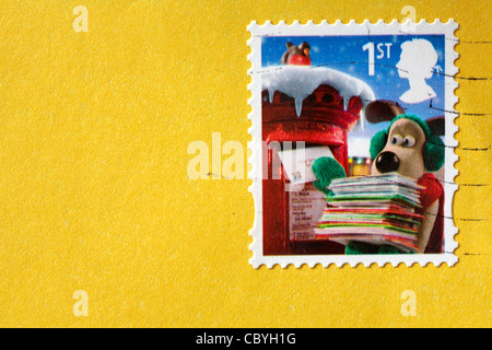 1st class Wallace & Gromit Christmas stamp stuck on yellow envelope Stock Photo