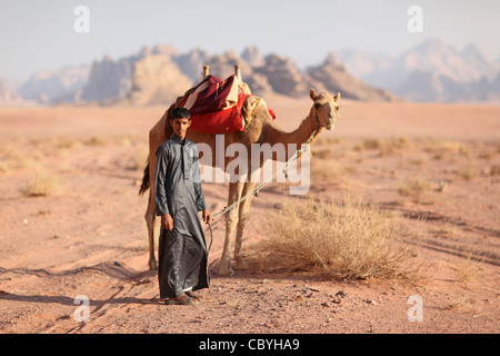 Young arab boy with camel, in the desert of Wadi Rum, Jordan Stock Photo