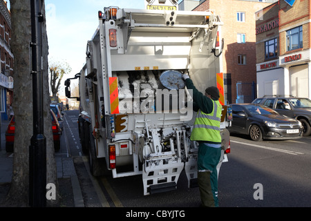 veolia worker working on behalf of local brent council collecting refuse waste in a bin lorry london uk united kingdom Stock Photo