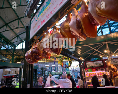 Christmas Borough market legs ham hams air curing on display for sale and selling at Festive Christmas Market meat butchers stall Southwark London UK Stock Photo
