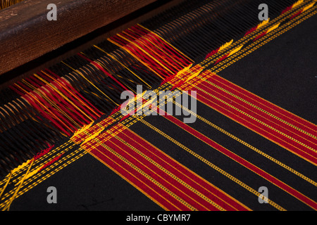 India, Arunachal Pradesh, Along, Paya village, handloom weaving, dark striped cloth being woven for local costume Stock Photo