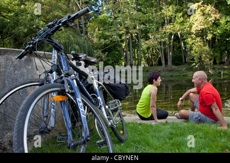 BICYCLE TOURISM. CYCLISTS RELAXING ON THE BANKS OF THE EURE, SAINT-PREST, NEAR CHARTRES, EURE-ET-LOIR (28), CENTRE, FRANCE Stock Photo