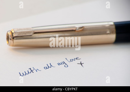 the words 'with all my love' handwritten in ink with fountain pen in background Stock Photo