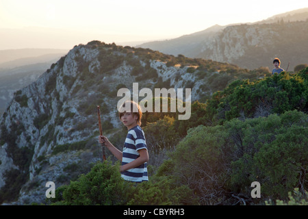 CHILDREN PLAYING ON THE ROCKS, CREST OF THE LITTLE LUBERON ABOVE THE VILLAGE OF BONNIEUX, VAUCLUSE (84), FRANCE Stock Photo