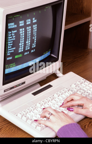 Woman working on old computer doing her household budget Stock Photo