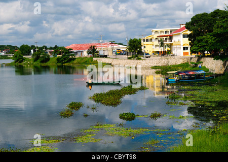 FLORES, Guatemala - Part of the waterfront of Flores in Lake Peten Itza, with small traditional boats moored against the shallows against the shoreline. Stock Photo