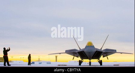 A 90th Aircraft Maintenance Unit crew chief signals an F-22 Raptor pilot laden with concrete bombs to begin its departure for a training mission at Elmendorf Air Force Base, Alaska. The F-22 performs both air-to-air and air-to-ground missions allowing full realization of operational concepts vital to the 21st century Air Force. Stock Photo