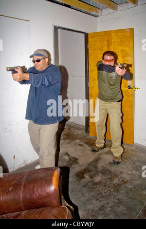 Under the eye of an instructor, law enforcement agents practice entering or 'breaching' a room with weapons. Stock Photo