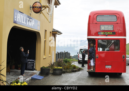 Sightseeing tour on a London red double decker bus stopping at Hilltop cafe, Banks Peninsula, South Island, New Zealand. Stock Photo