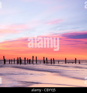 Old sea defences at dawn, smooth water from long exposure. Stock Photo