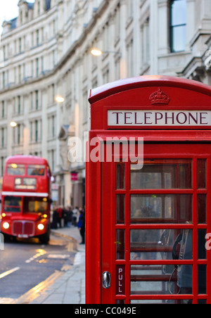 Traditional London old red telephone box and old double decker in background. Stock Photo