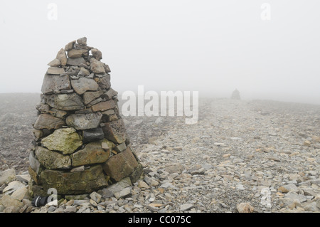 This image shows two cairns on top of Ben Nevis, Scotland, along a path that allows visitors to find there way to the summit Stock Photo