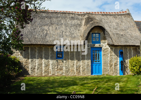 Pretty thatched cottage in Brittany France made of long standing granite stones, a style unique to this area. Stock Photo