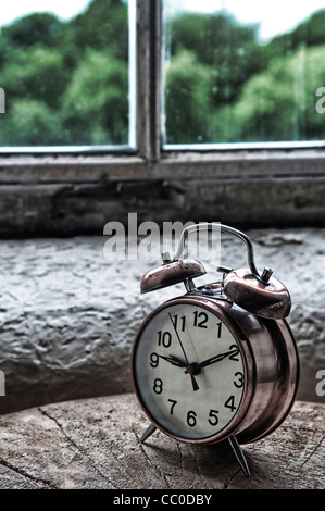 Vintage metal alarm clock by the window Stock Photo
