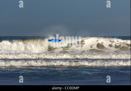 A surfer wipes out on a big wave at Porthtowan beach, Cornwall. Stock Photo
