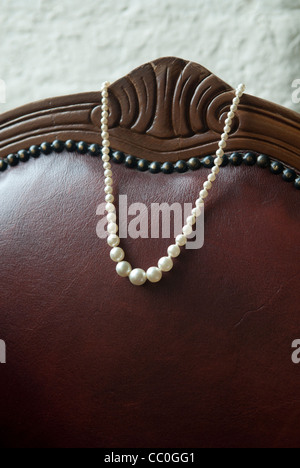 Pearl necklace on leather couch Stock Photo