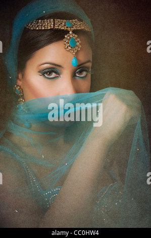 Beautiful Indian woman hiding face with a blue veil Stock Photo