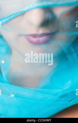 Detail of an Indian woman's mouth covered with a blue veil Stock Photo