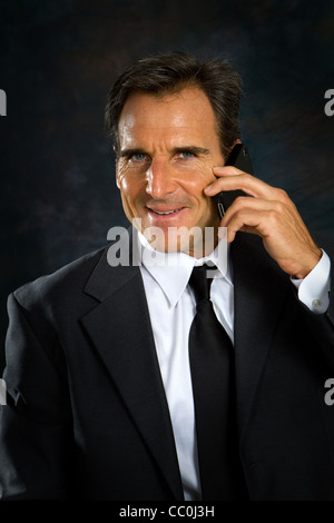 Businessman, white collar worker, in business suit talks on his cell phone. Stock Photo