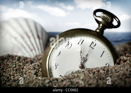 Old pocket watch buried in sand Stock Photo