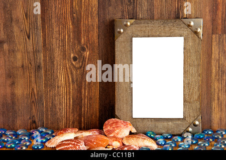 Wooden frame with shells and blue stones on brown wooden background - perfect for vacation pictures Stock Photo