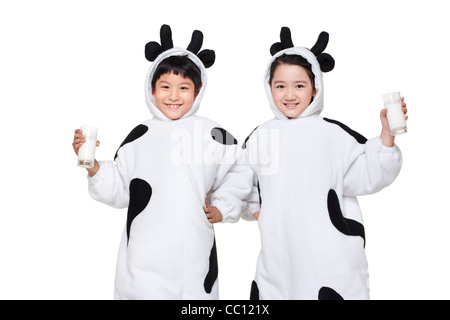 Children in cow costumes with glasses of milk Stock Photo