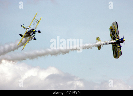 The UK Utterly Butterly display team perform an aerobatic manoeuvre with their Boeing Stearmans, at an air display in England. Stock Photo