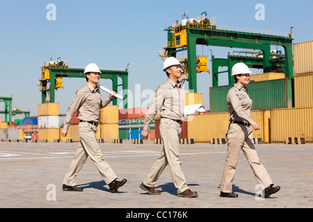 shipping industry workers walking in a row Stock Photo