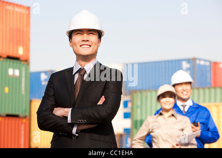 businessman with shipping industry workers in the background Stock Photo