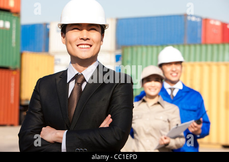 businessman with shipping industry workers in the background Stock Photo