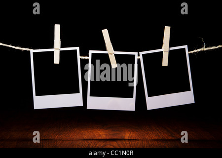 three blank instant photos on the background of a wooden table Stock Photo
