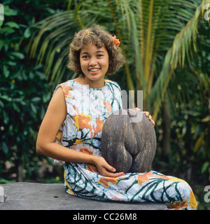 MR, Young Creole woman with a Coco de Mer nut, Praslin island, Seychelles Stock Photo