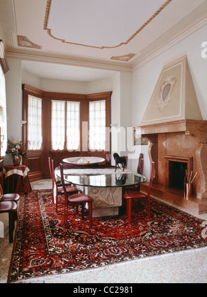 dining room with marble fireplace and large carpet in a ancient residence Stock Photo