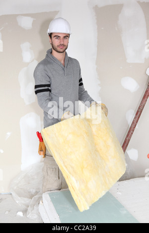 Worker handling square of insulation Stock Photo