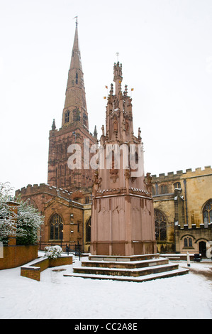 The 1976 replica Coventry Cross Monument in front of Holy Trinity Church, made by sculptor George Wagstaffe. Coventry, UK, in snow. Stock Photo