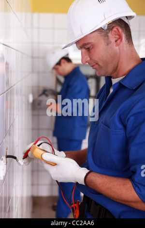 Electricians installing switches Stock Photo