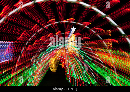 Abstract multi-coloured pattern of electric lights radiating out from a central point, against a black background Stock Photo