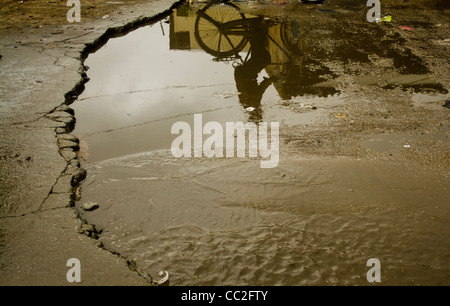 reflections in a pothole filled with rain water Stock Photo