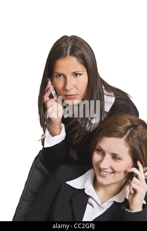 Portrait of two young businesswomen using mobile phones. Stock Photo