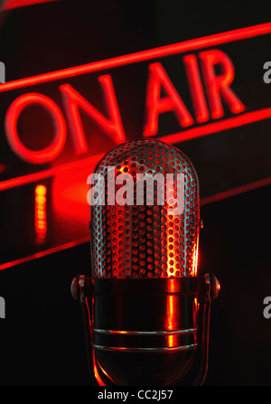 Vintage microphone and red on air neon, studio shot Stock Photo