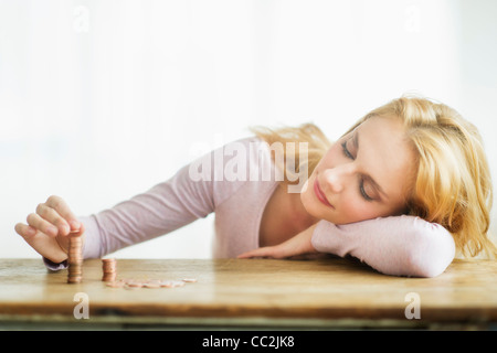 Woman stacking coins, studio shot Stock Photo