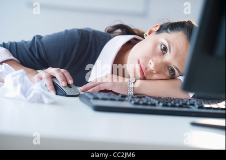 USA, New Jersey, Jersey City, Businesswoman in front of computer, looking tired Stock Photo