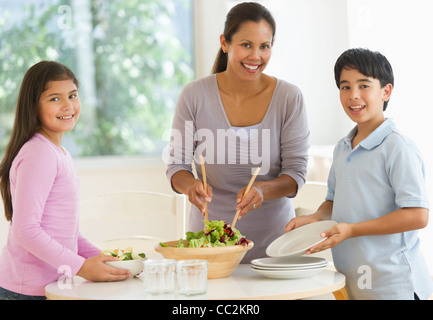 USA, New Jersey, Jersey City, Mother with son (12-13) and daughter (10-11) preparing salad Stock Photo