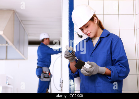 Male and female electricians working together Stock Photo