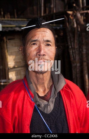 India, Arunachal Pradesh, Ziro Valley, Hong village elder in red coat with tattooed chin and pin through hair Stock Photo