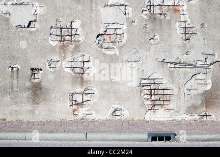 Decaying concrete wall with sidewalk Stock Photo