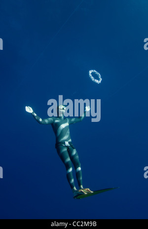 Freediver tries to swim through the bubble air ring at the depth of Blue Hole, Dahab, Egypt Stock Photo