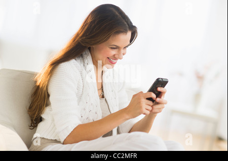 USA, New Jersey, Jersey City, Woman using smart phone at home Stock Photo