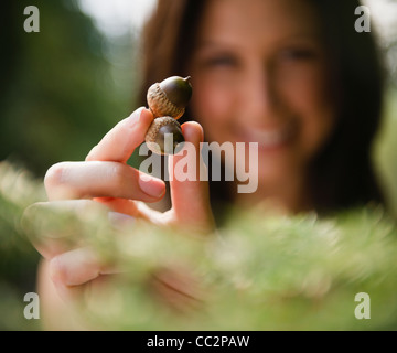 USA, New York, Putnam Valley, Roaring Brook Lake, Close up of woman's hand holding acorns Stock Photo